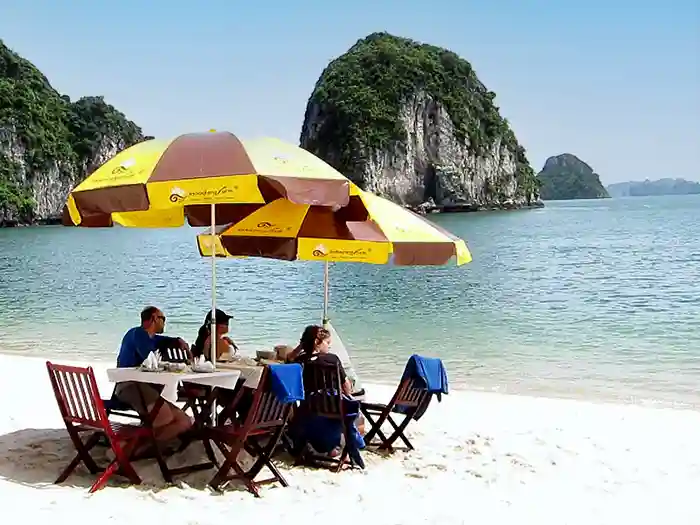 Family dining on a private beach cove, Halong Bay